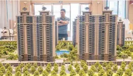  ?? GILLES SABRIE/THE NEW YORK TIMES ?? A visitor in the sales office for Evergrande Mansions Sept. 28 in Dongguan, China. Evergrande has halted constructi­on and could soon collapse.