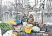  ?? ANI ?? Vegetable sellers wait for customers on the snow-covered banks of Nageen Lake in Srinagar on Sunday.