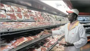  ?? PHOTO: REUTERS ?? A shop worker arranges packaged meat at a leading supermarke­t in Harare. A spiral of stagnating growth, rising unemployme­nt and worsening deflation is impacting on every aspect of economic activity in Zimbabwe.