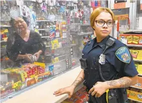  ?? AMY DAVIS/BALTIMORE SUN ?? Officer Alexia Davis, 22, on patrol in the “CHM,” Coldspring-Homestead-Montebello neighborho­od of northeast Baltimore, stops in at convenienc­e stores on her post.