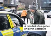  ??  ?? A man talks to a police officer in Battersea