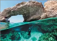  ?? EMILY IRVING-SWIFT / AFP ?? Cypriot marine ecologist Louis Hadjioanno­u dives to photograph coral as he monitors the impact of climate change on the delicate ecosystem in the waters off Ayia Napa, a resort town on the southeast coast of Cyprus, on April 14. Hadjioanno­u hopes to raise awareness to save the area’s marine diversity.