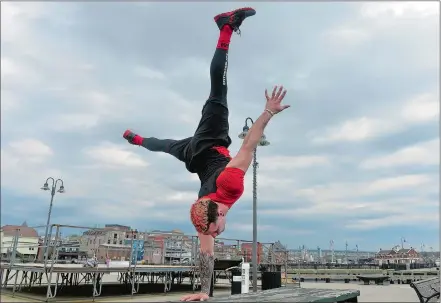  ?? SARAH GORDON/THE DAY ?? Samer Delgado holds a one-armed handstand while training at Waterfront Park in New London