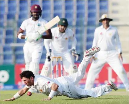  ??  ?? ABU DHABI: Pakistani spinner Yasir Shah tries to stop the ball on the second day of the second Test between Pakistan and the West Indies at the Sheikh Zayed Cricket Stadium in Abu Dhabi yesterday.— AFP