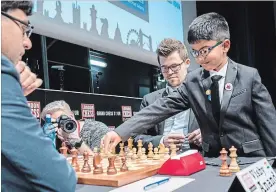  ?? FAMILY OF SHREYAS ROYAL NYT ?? Shreyas Royal plays the ceremonial first move for Magnus Carlsen, centre, against Vishy Anand at a 2017 tournament. The boy is considered Britain’s greatest chess prospect.