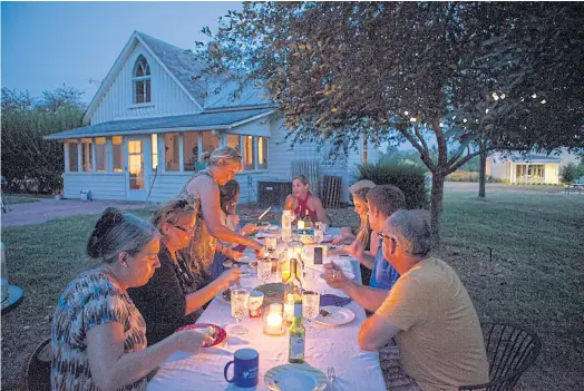  ??  ?? CELEBRATIO­N: Beth Howard hosts a cast party for a local arts group in the backyard, with a view of a second Gothic window on the home’s back side.