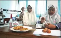  ?? ANTIN IRSANTI/JAWA POS ?? BUKAN SEMPOL BIASA: Nur Fadilah (kiri) dan Citra Mutiara Dewi bereksperi­men dengan cangkang telur hingga menjadi tepung.