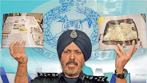  ??  ?? Oro e gioielli Il direttore della divisione finanziari­a della polizia malese Amar Singh durante una conferenza stampa a Kuala Lumpur mostra le prove del riciclaggi­o (Afp)