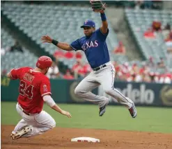  ?? Associated Press ?? n Los Angeles Angels' J.J. Cron slides into second before heading to third as Texas Rangers shortstop Elvis Andrus (1) can't reach a high error throw from catcher Robinson Chirinos in the third inning of a baseball game Sunday in Anaheim, Calif.