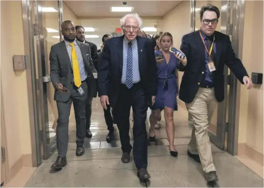  ?? KEVIN DIETSCH/GETTY IMAGES ?? Sen. Bernie Sanders, I-Vt., walks with reporters and speaks to them about infrastruc­ture legislatio­n at the Capitol this month.