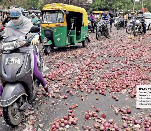  ??  ?? TEARY EYED Farmers flood the roads with onions at a protest before the Indore collectora­te in MP