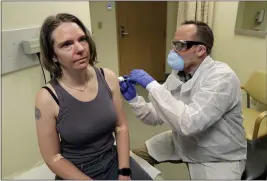  ?? TED S. WARREN — THE ASSOCIATED PRESS FILE ?? A pharmacist gives Jennifer Haller, left, the first shot in the first-stage safety study clinical trial of a potential vaccine for COVID-19 at the Kaiser Permanente Washington Health Research Institute in Seattle on March 16.