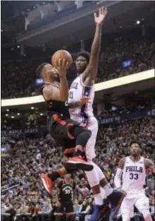  ?? CHRIS YOUNG/THE CANADIAN PRESS VIA AP ?? Toronto Raptors’ Norman Powell, left, shoots on Philadelph­ia 76ers’ Joel Embiid, right, during Saturday’s game.