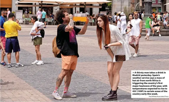  ?? Paul White/Associated Press ?? A thirsty man takes a drink in Madrid yesterday. Spain’s weather service says a mass of hot air from north Africa is triggering the country’s first major heatwave of the year, with temperatur­es expected to rise to 43C (109F) in certain areas of the country early this week.