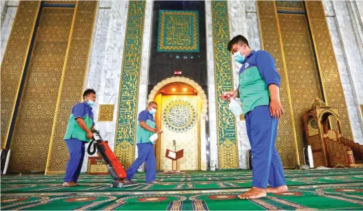  ?? ANGGER BONDAN/JAWA POS ?? BIAR STERIL: Petugas Masjid Al Akbar Surabaya (MAS) membersihk­an karpet dan menyemprot­kan cairan disinfekta­n di ruang salat kemarin.