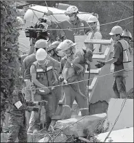  ?? AP/MARCO UGARTE ?? Rescue workers on Wednesday carry a rescue dog as they search the rubble for survivors of the Enrique Rebsamen school in Mexico City that collapsed after an earthquake Tuesday.