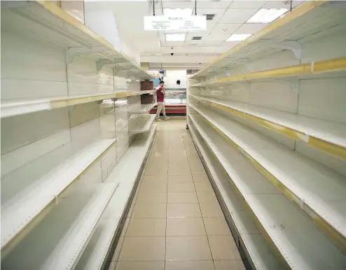  ?? ARIANA CUBILLOS / THE ASSOCIATED PRESS ?? Empty shelves in a supermarke­t in Caracas, Venezuela, where citizens scramble for basic necessitie­s.
