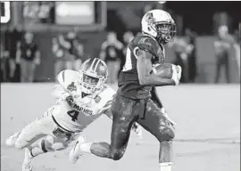  ?? John Raoux Associated Press ?? CENTRAL FLORIDA’S Greg McCrae, right, runs past Memphis’ Josh Perry in the second half of the American Athletic Conference title game in Orlando, Fla.