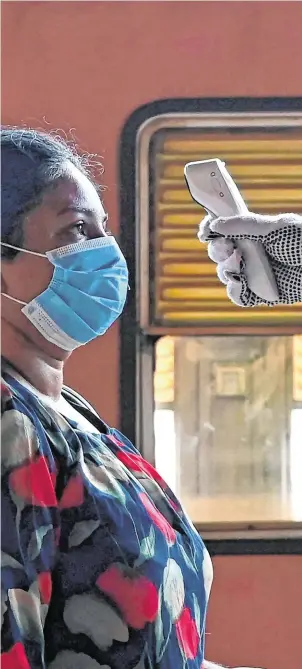  ?? PHOTO: GETTY ?? New measure: A worker in the Sri Lankan capital Colombo has her temperatur­e checked before she is allowed in to her office.