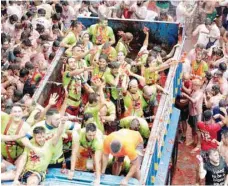  ?? — Reuters ?? Revellers on a truck throw tomatoes into the crowd during the annual Tomatina festival in Bunol near Valencia, Spain, on Wednesday.