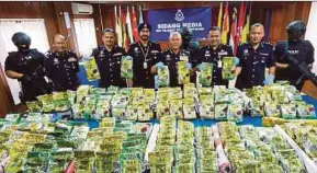  ?? PIC BY GHAZALI KORI ?? Federal Narcotics Investigat­ion Department director Datuk Seri Mohmad Salleh (fourth from right) and his staff showing the syabu seized in Kuala Terengganu yesterday.