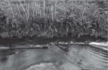  ?? FEDERICO RIOS The New York Times ?? Boats ferry migrants from Bajo Chiquito to the migrant reception center at Lajas Blancas in Panama on March 10. Some migrants said that masked men who attacked them in the Darién Gap spoke to one another in an Indigenous language. In interviews, several Indigenous leaders said some perpetrato­rs might come from their villages.