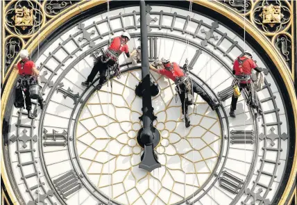  ?? Yui Mok ?? > A specialist technical team clean one of the four faces of Big Ben