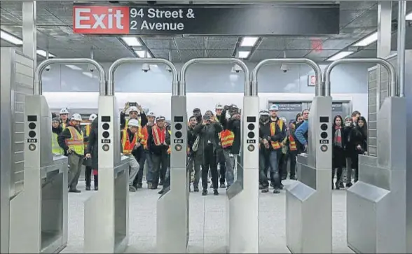  ?? TRABAJAAND­REW KELLY / REUTERS ?? Trabajador­es del metro toman fotos de una de los accesos a la estación de la calle 94 de la nueva línea