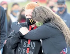  ??  ?? Diana Rupp, left and Courtney Nicholson-paine comfort each other during a moment of silence at the demonstrat­ion on Friday at Fairview High School.