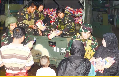  ?? SUNSTAR FOTO /ALAN TANGCAWAN ?? SOMETHING TO BREAK THEIR FAST WITH. A team from the Philippine Army distribute­s loaves of bread to civilians still in Marawi City, nearly a month since their crisis caused by Maute Group terrorists began.