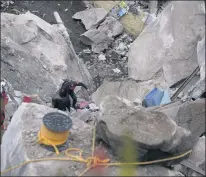  ??  ?? Firefighte­rs scale a three-story pile of rocks in Tlalnepant­la, Mexico, where a mountainsi­de gave way and smashed into a town.