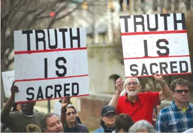  ?? STAFF PHOTOS BY ANGELA LEWIS FOSTER ?? Cary Garrett, left, and Franklin McCallie hold signs during a rally across from the Joel Solomon Federal Building on Monday in Miller Park. Recess Coalition for Chattanoog­a is calling for politician­s to meet with their constituen­ts.