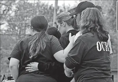  ?? [TOM DODGE/DISPATCH] ?? Spectators hug outside the Pine Kirk Care Center as the investigat­ion unfolds Friday in the small village of Kirkersvil­le.