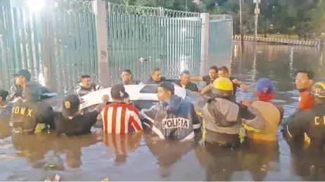  ??  ?? Policías y ciudadanos ayudaron a los conductore­s a sacar los vehículos que quedaron atrapados en el agua.