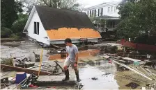  ?? AP ?? Resident Joseph Eudi looks at the debris and storm damage from Hurricane Florence at a home on East Front Street in New Bern on Saturday.