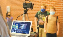  ?? AP-Yonhap ?? Corinth Elementary School students have their temperatur­e checked by a thermal scanner as they arrive for their first day back to school in Corinth, Miss., July 27.