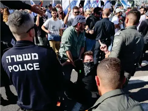  ?? (AFP) ?? An anti - government protester is dragged away by police in Tel Aviv yesterday