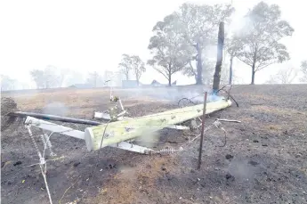  ??  ?? A smoulderin­g utility pole on the ground following bushfires in the outskirts of Quaama, New South Wales.