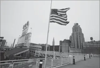  ?? MARK DUNCAN, THE ASSOCIATED PRESS ?? The United States flag flies at half mast for the victims of the Monday bombing at the Boston Marathon on Tuesday at Progressiv­e Field in Cleveland before a baseball game between the Boston Red Sox and the Indians.