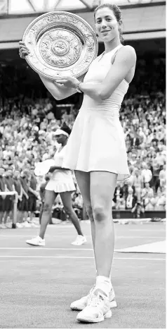  ?? — AFP photo ?? Spain’s Garbine Muguruza holds up The Venus Rosewater Dish as she celebrates beating US player Venus Williams to win the women’s singles final on the twelfth day of the 2017 Wimbledon Championsh­ips at The All England Lawn Tennis Club in Wimbledon,...