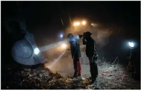  ?? AP PHOTO/BERNAT ARMANGUE ?? Members of NGOs Deathcare Embalming Team and Turkish Kurt-Ar inspect the bucket of an excavator Friday as they search for bodies of people who died during the earthquake in Kahramanma­ras, Turkey.