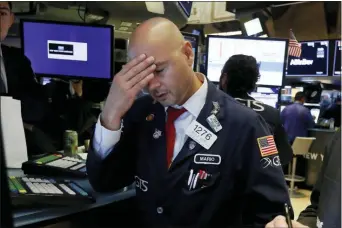  ?? RICHARD DREW — THE ASSOCIATED PRESS ?? Specialist Mario Picone works on the floor of the New York Stock Exchange, Wednesday. The Dow Jones Industrial Average sank 800 points after the bond market flashed a warning sign about a possible recession for the first time since 2007.