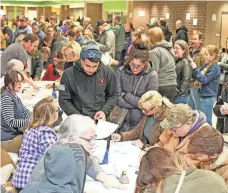  ?? LEE NAVIN/FOR THE REGISTER ?? Johnston, Iowa, residents debate their choices during the 2020 Democratic caucus. A tangle of issues tied to technology and organizati­on marred that year’s contest in the state.
