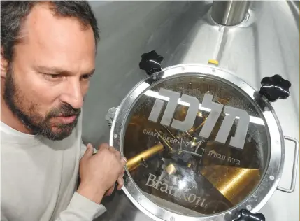  ?? (Photos: Mike Horton) ?? ASSAF LAVI inspects the brewing kettle in the new Malka Brewery in Tefen.