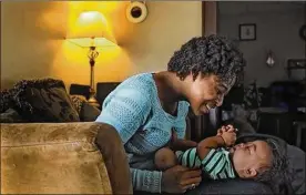  ?? ERIC ALBRECHT / DISPATCH ?? Liasun Hodges plays with her 6-month-old son, Damani, who was born with Down syndrome. The Down Syndrome Associatio­n of Central Ohio is stepping up outreach efforts to get more minority families involved.
