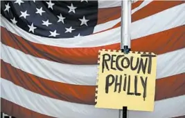 ?? REBECCA BLACKWELL/AP ?? A sign hangs Tuesday in Philadelph­ia during a protest by supporters of President Trump. The president’s loyalists have filed 15 challenges in Pennsylvan­ia in wake of the election.