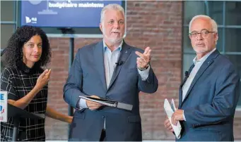  ?? JACQUES NADEAU LE DEVOIR ?? Le premier ministre sortant, Philippe Couillard(au centre), a présenté mercredi le cadre financier du PLQ aux côtés des candidats Carlos Leitão et Dominique Anglade.