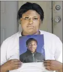  ?? TAE-GYUN KIM / AP ?? At her home in Chicago, Monique Causey holds a portrait of her 14-yearold son, Malik, who was shot Aug. 21. Chicago has seen at least 595 homicides so far this year.