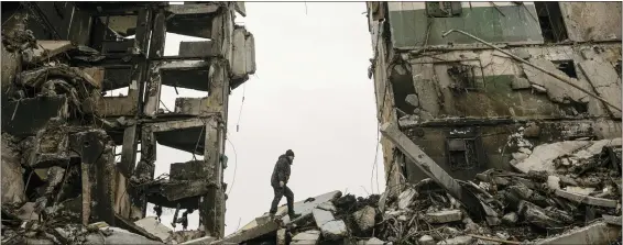  ?? ASSOCIATED PRESS FILE ?? A resident looks for belongings in an apartment building destroyed during fighting between Ukrainian and Russian forces in Ukraine.