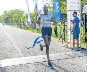  ??  ?? LEFT: Sheleca Grant crossing the finish line in 22 minutes and 10 seconds at the sixth staging of the Colour Me Happy 5K Powder Run to take home the winning trophy in the women’s under-16 category.